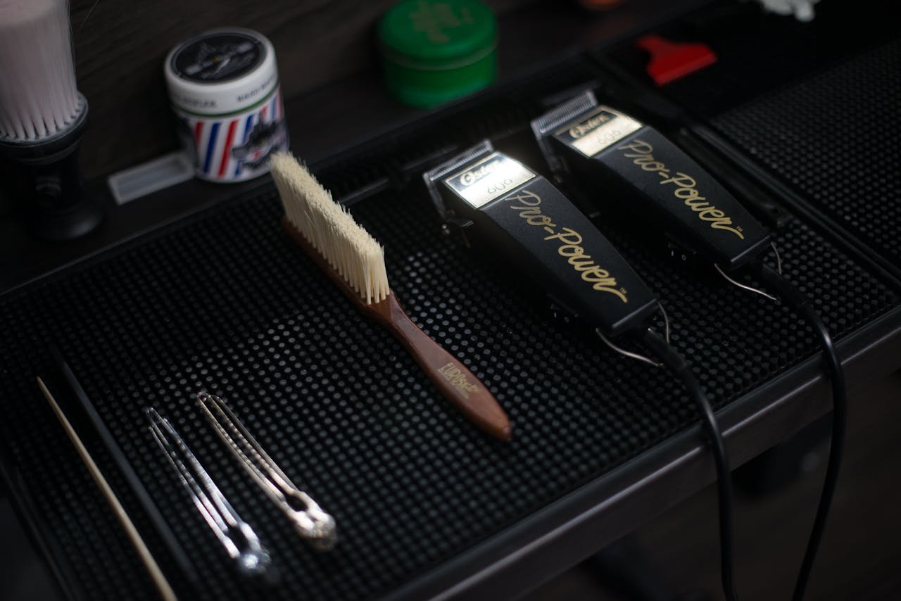 Close-up of hair clippers and grooming tools in a modern barbershop setup.
